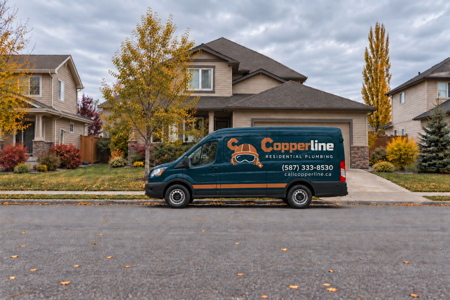 A dark teal Copperline Residential Plumbing van with copper lettering, parked on a residential street in front of a two-storey house with autumn trees in the yard.